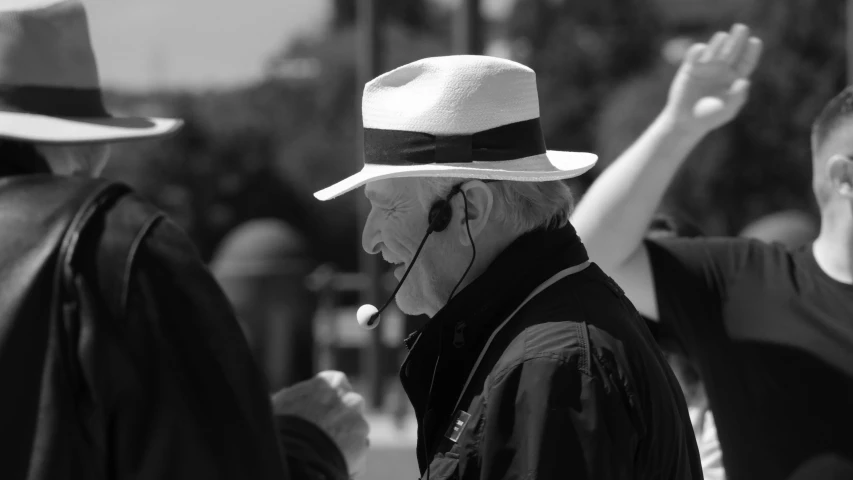 a man with a hat on and his hand up