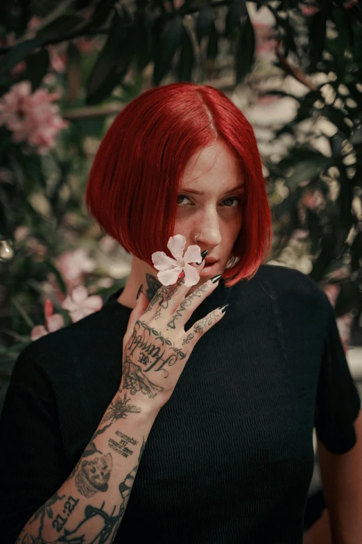 a woman with tattoos and a flower in her hand