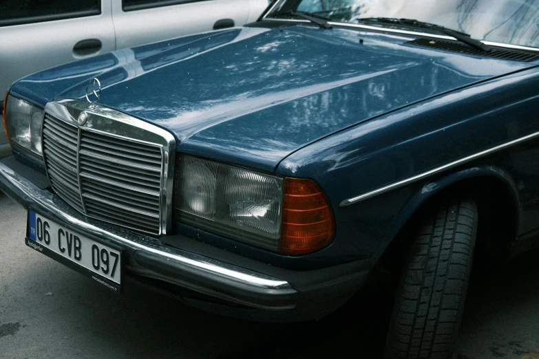 a dark blue mercedes benz parked next to a white car