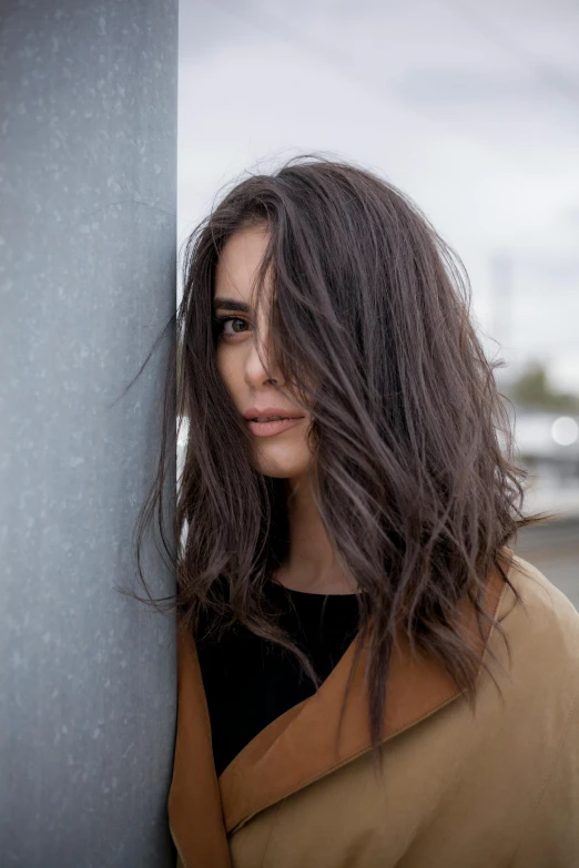 a woman is leaning against a pole, outside