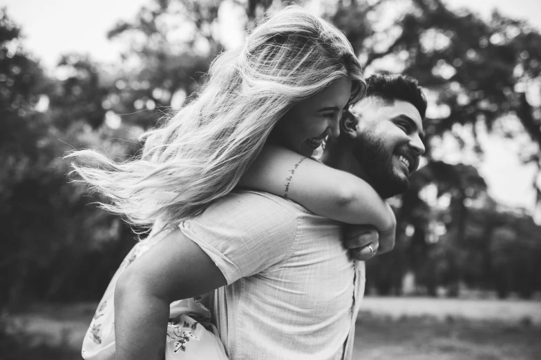 an engaged couple hugging in a black and white po