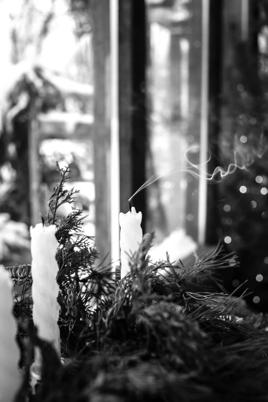 some candles that are sitting near a glass window