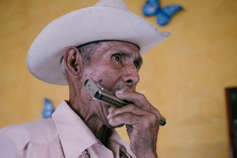 a man in a white hat smoking and talking on a cellphone