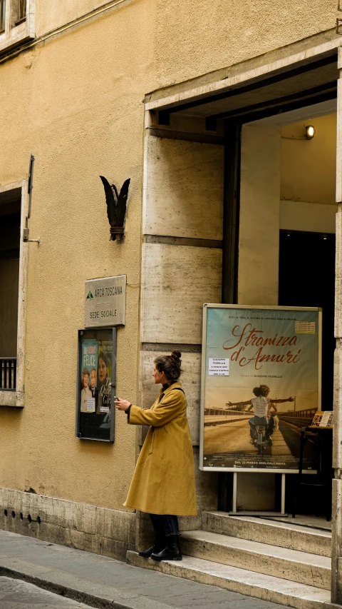 a person points to a poster in the doorway