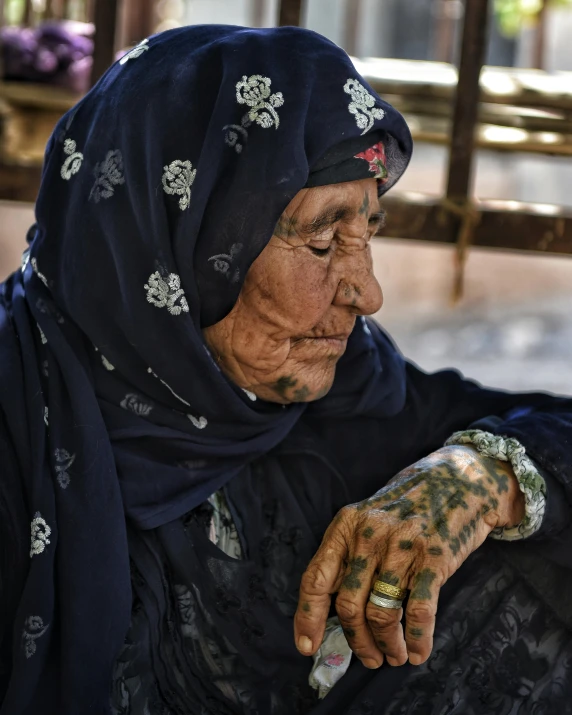 an elderly woman with black clothes and white jewelry