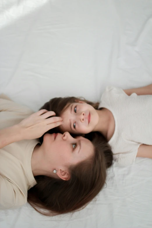 mother and daughter lying down on the bed together