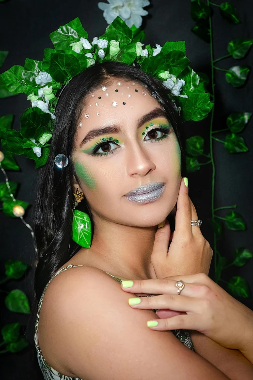 a woman with green and silver makeup posing for the camera