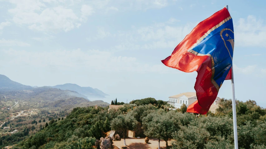 a large flag flying on top of a mountain