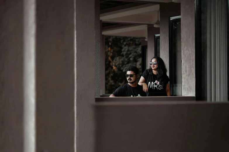 two people staring out a window with one woman and man in the reflection