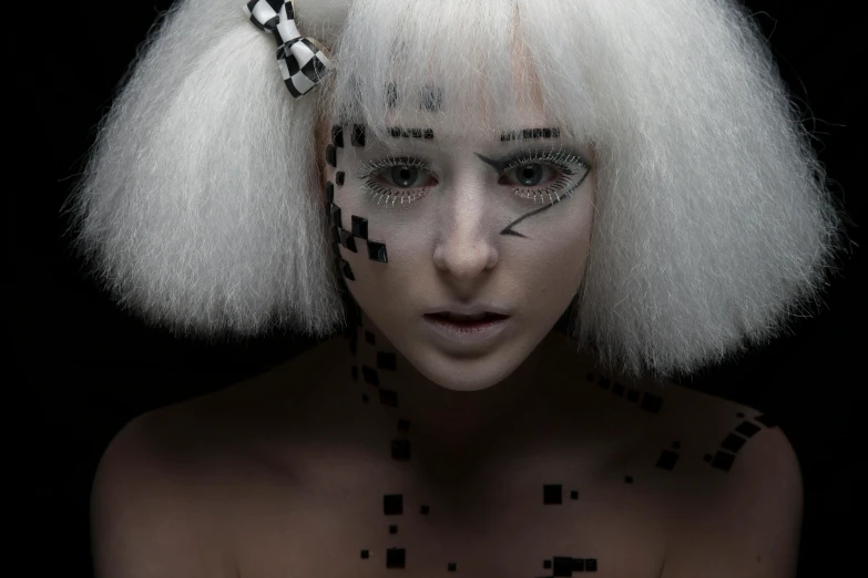 a woman with makeup and white hair, black markings, and a cross pattern on her face
