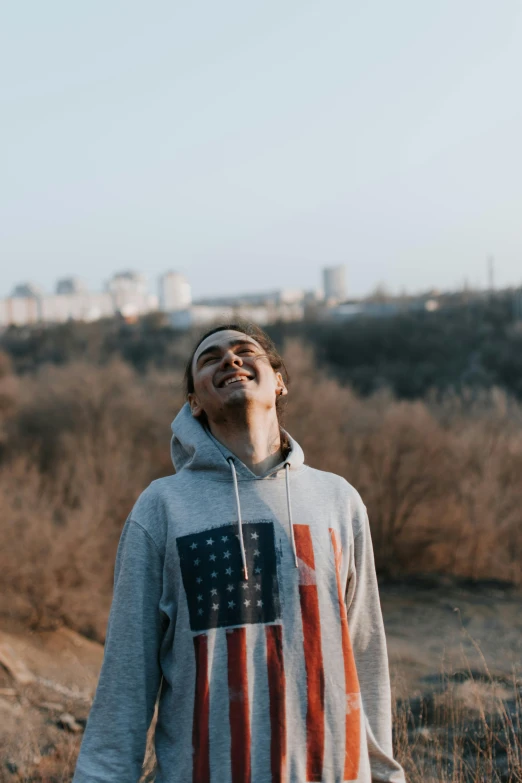 man standing on a hillside with american flag shirt on