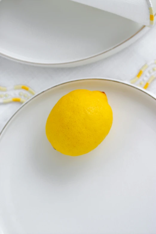 a lemon in a white bowl on top of a table