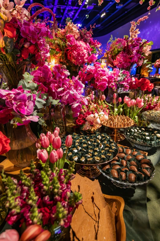 a table filled with cakes and flowers on it