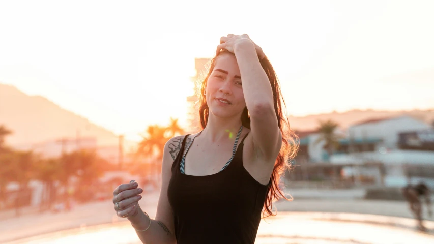 a person standing on the street with her arms in the air