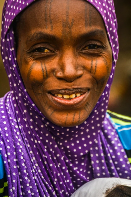 a woman with painted face and purple scarf