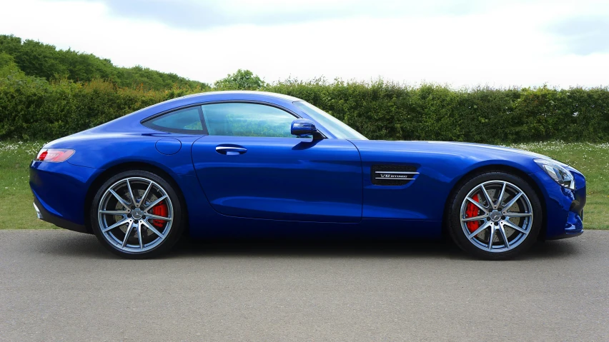 a blue sports car parked near some trees