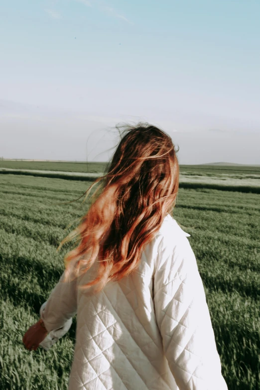 a woman standing in a field of green grass