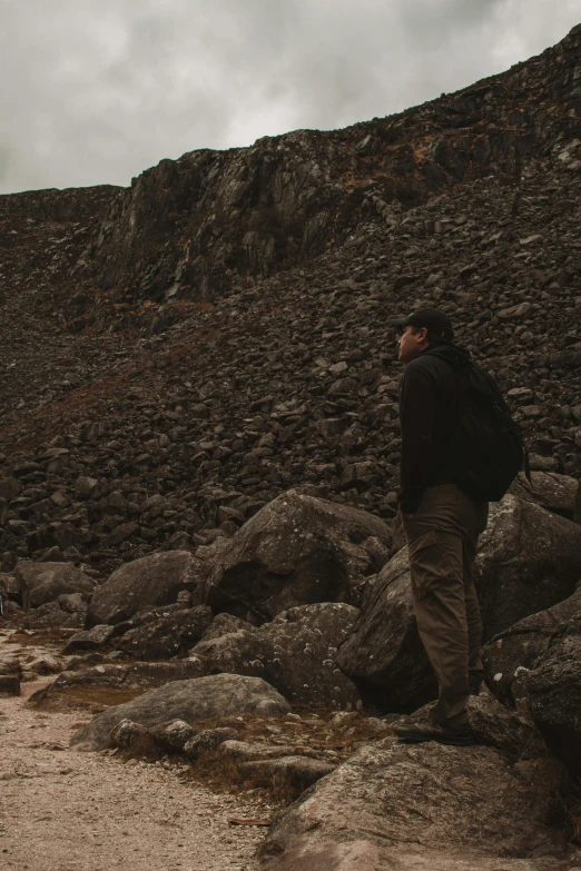 there is a person standing on rocks looking at the sky