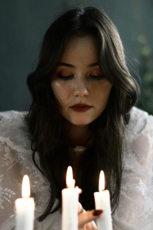 a girl looks at five candles with white candles