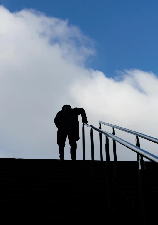 a person climbing up the steps towards the sky