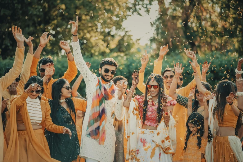 wedding guests throw confetti while bride and groom pose