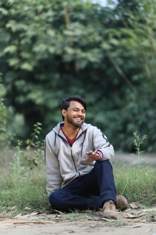 a man sitting on the ground smiling at the camera