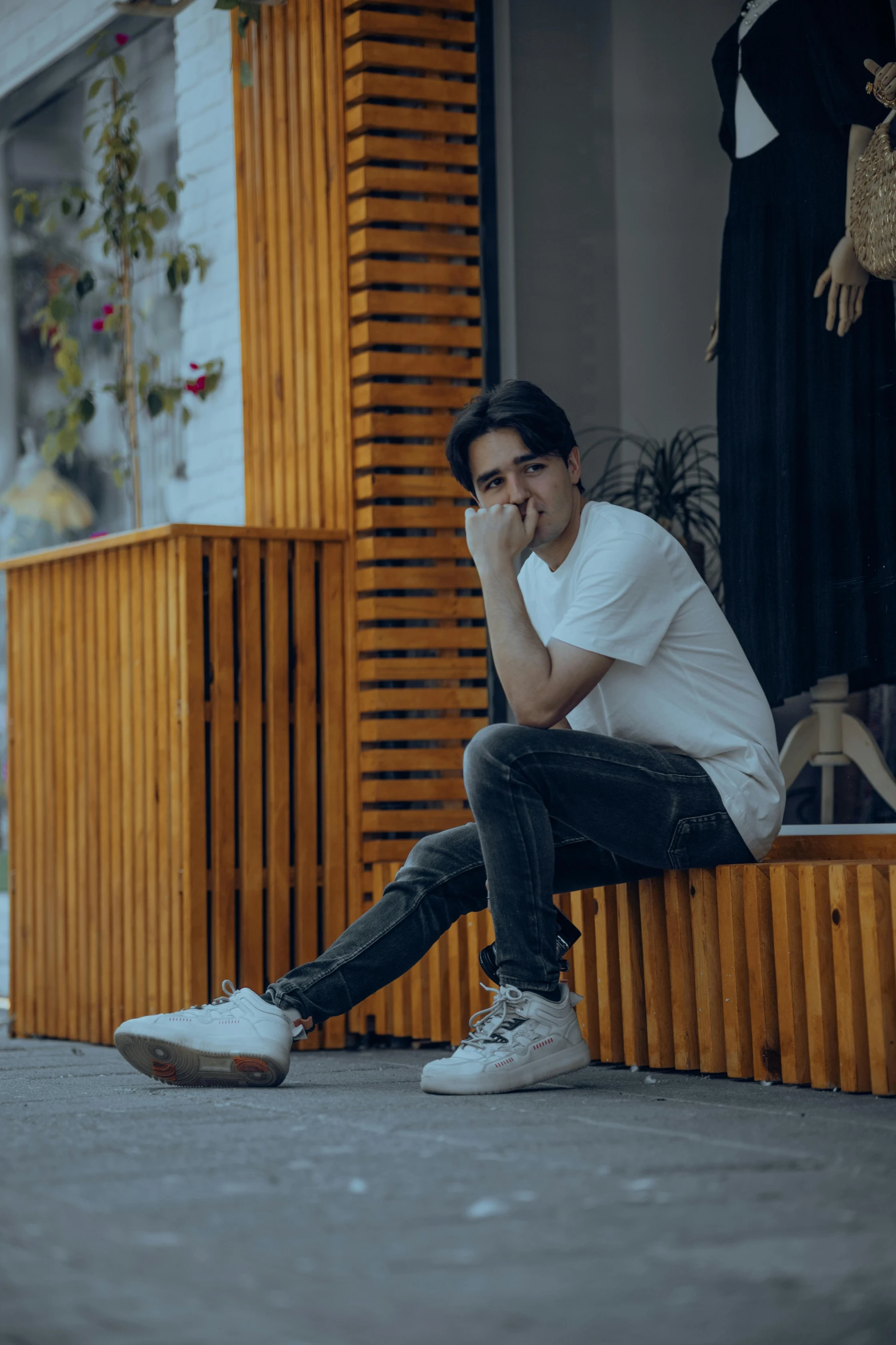 a man sits on the steps outside his shop