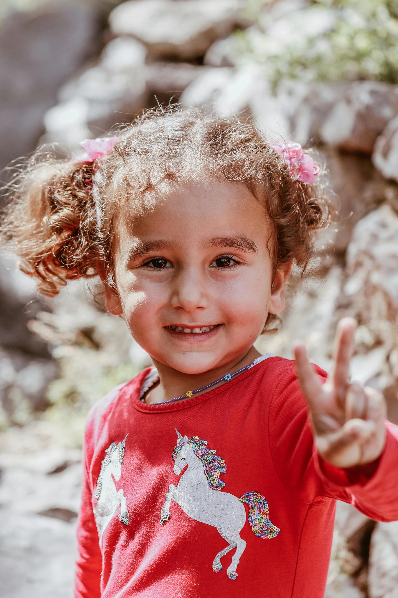 a  with curly hair holds up her fingers