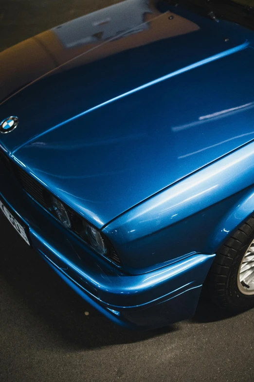 the shiny blue bmw car is parked next to a curb