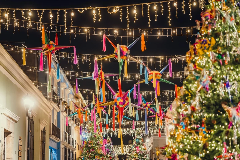 a street decorated with lights, decorated trees and lights