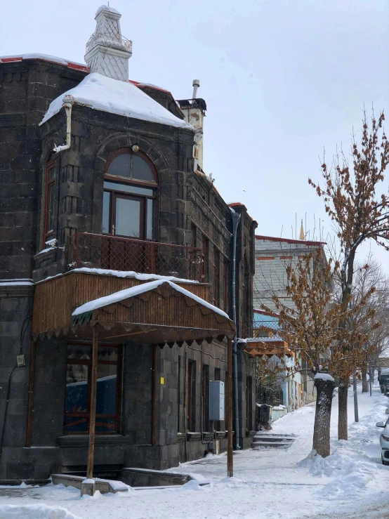 a street scene in winter with a snow covered sidewalk and old building
