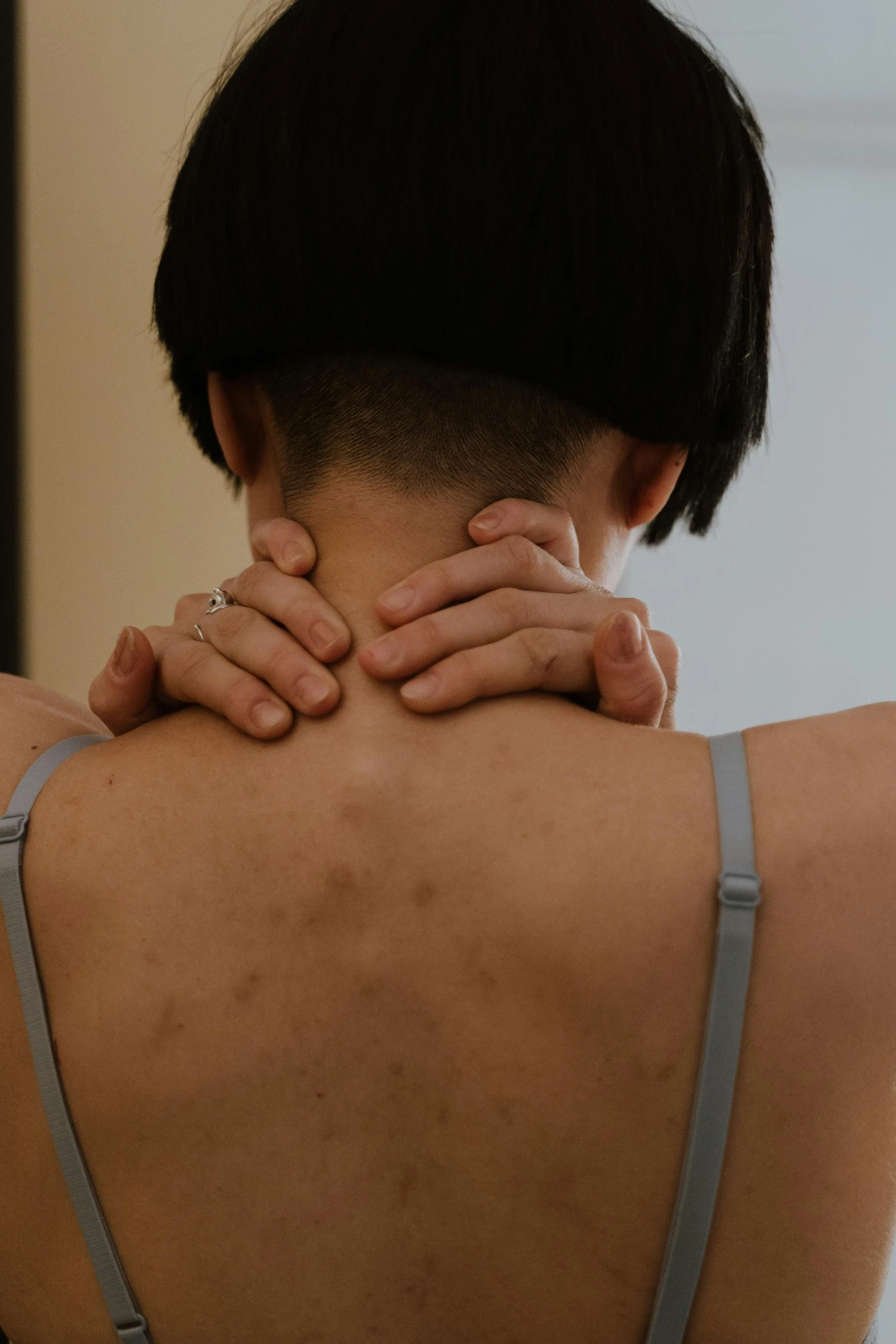 a woman holding her hands up to the neck