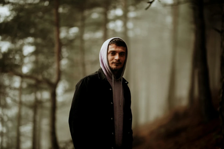 man walking alone in the woods wearing a purple scarf