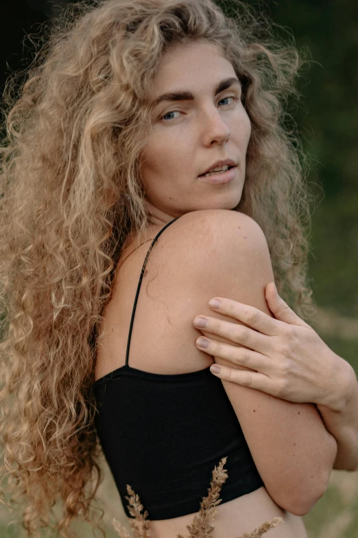 a young woman poses while hugging her body