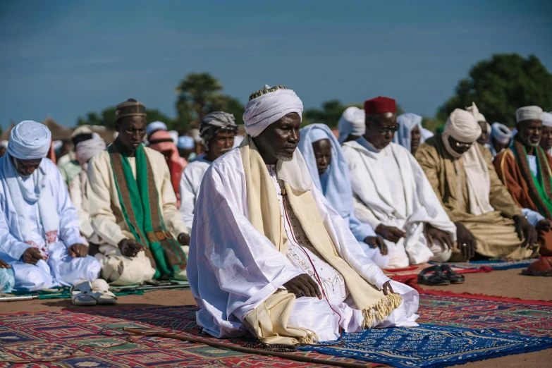 the people are sitting on the ground with their headscarves