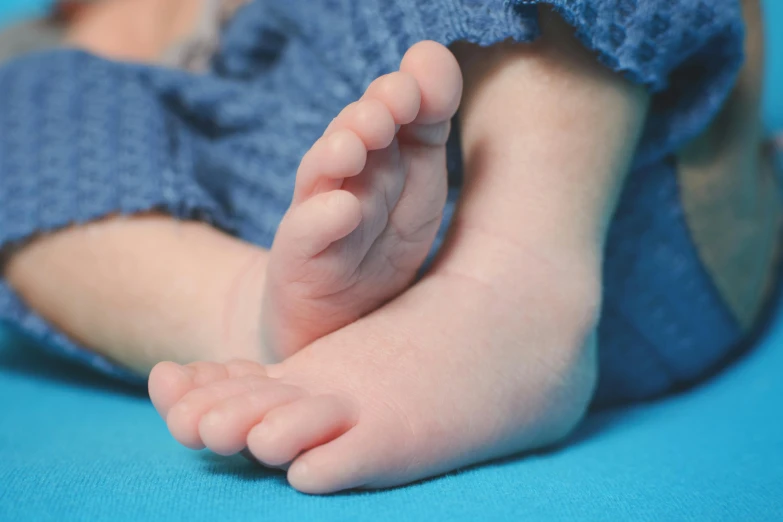 a baby laying on top of a blue blanket