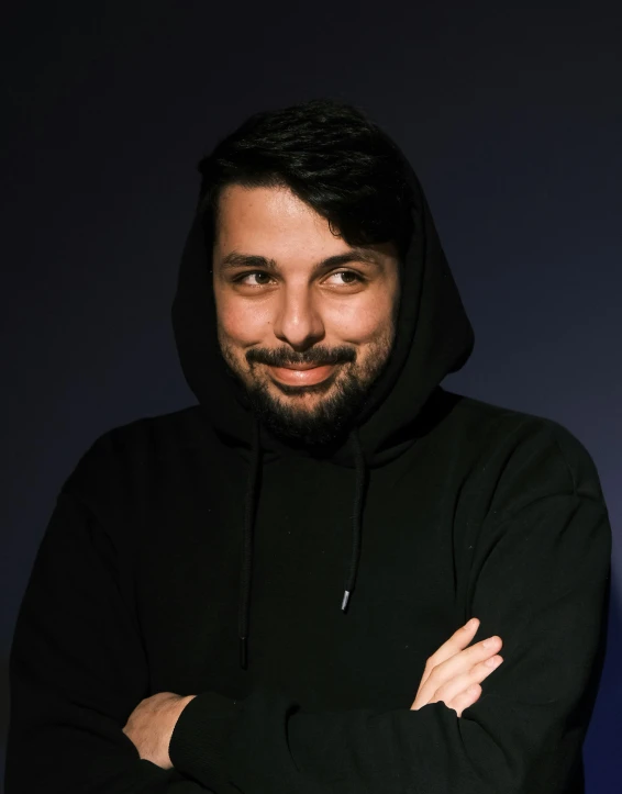man with hoodie and arms crossed posing for the camera