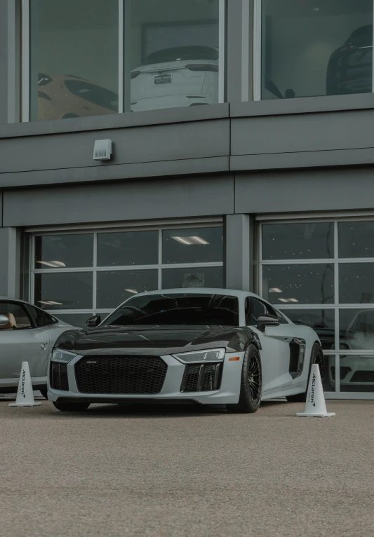 two sport cars are parked outside a building