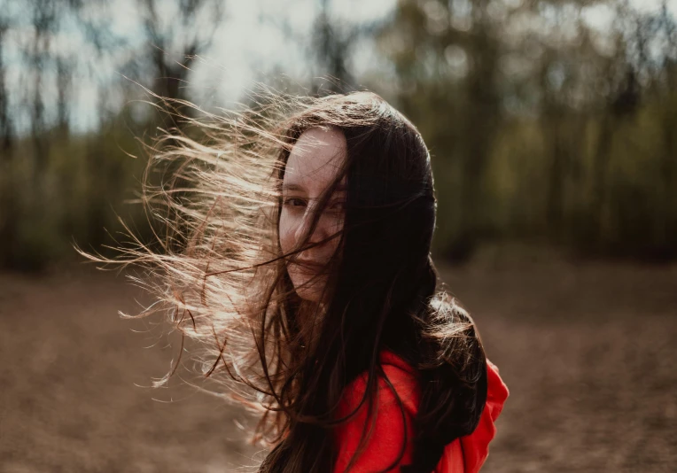 a woman with long, brown hair is walking through the dirt