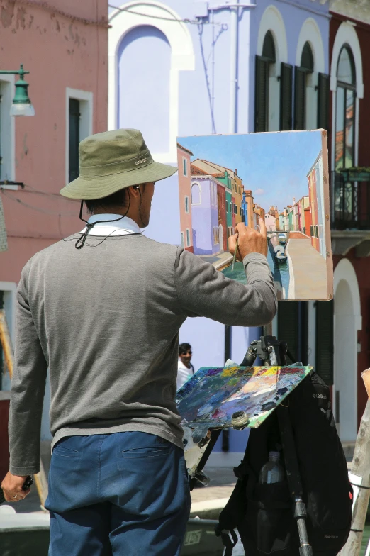 a man looking at a painting while standing on a stage