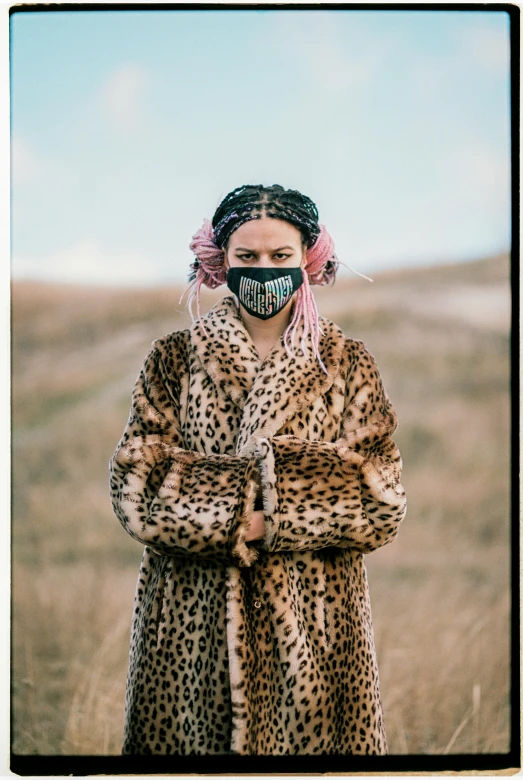 a woman wearing a mask standing on a field