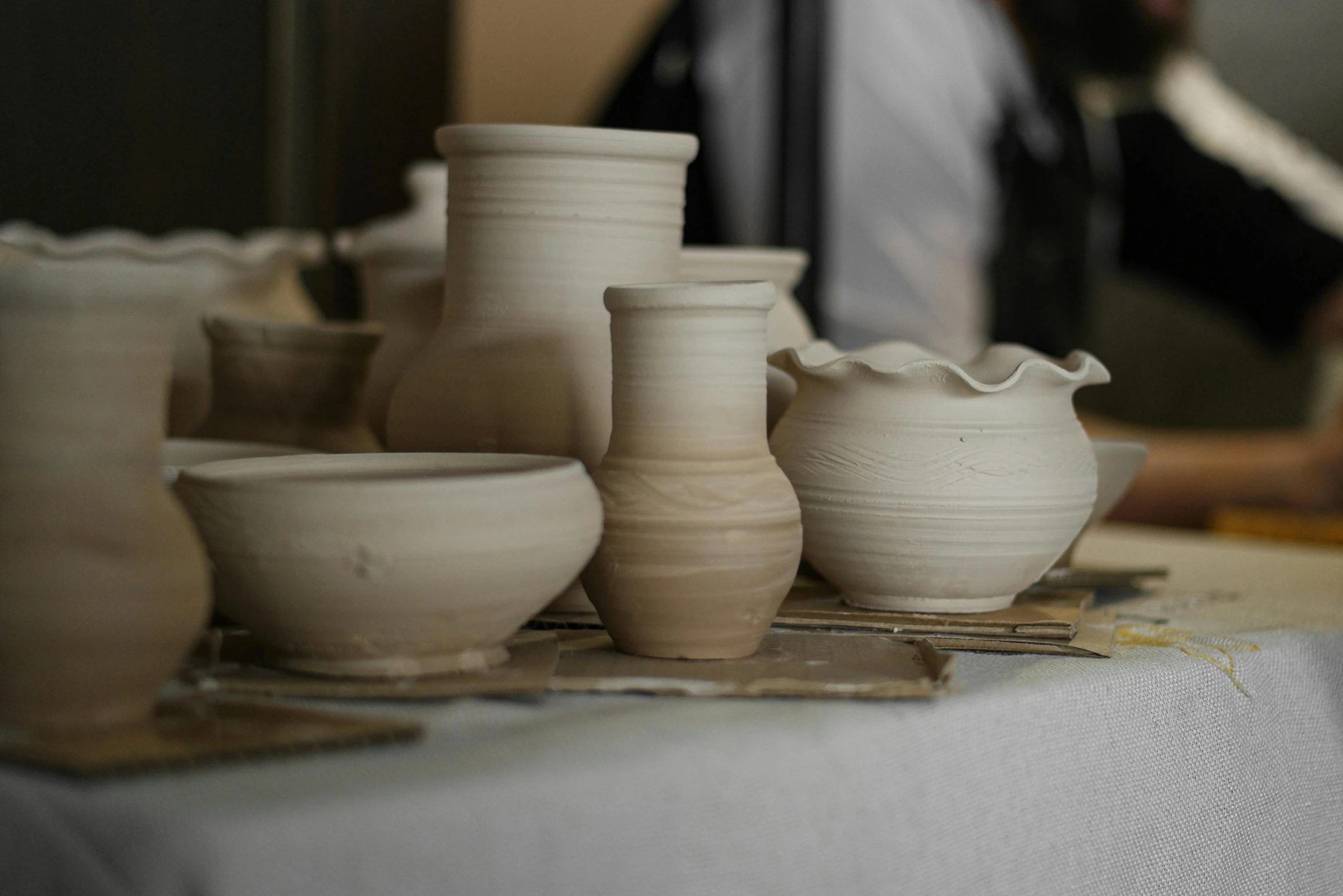 many pottery pieces and a man in the background