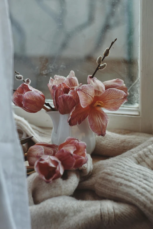 the flowers are in the vase on the windowsill