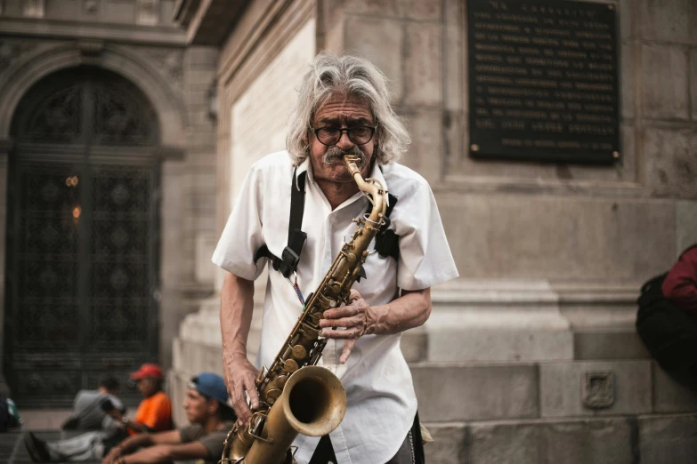 a man is playing the saxophone on a city sidewalk