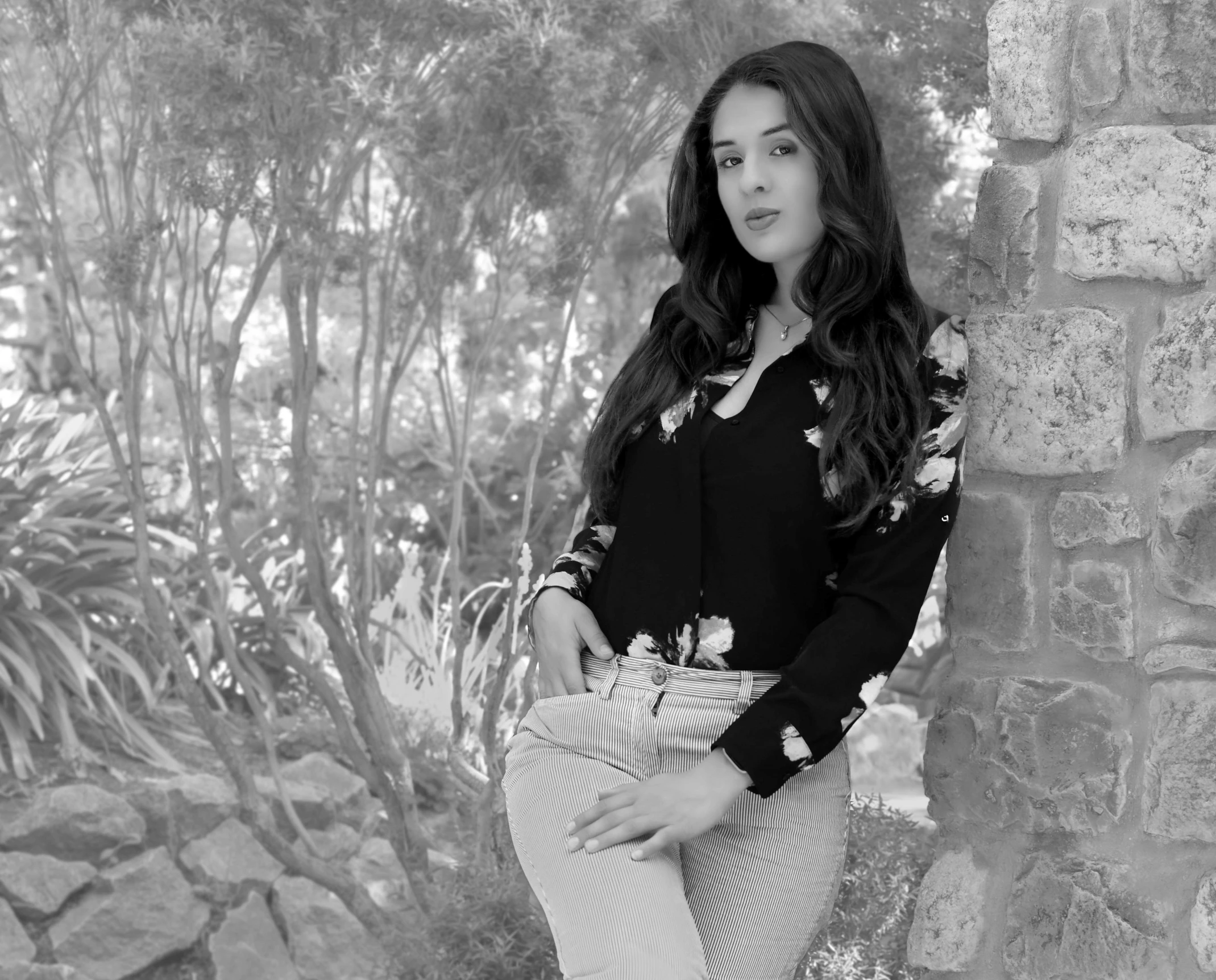 a young woman leaning against a wall posing for a picture