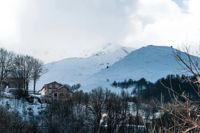 snow covers the mountains behind a house
