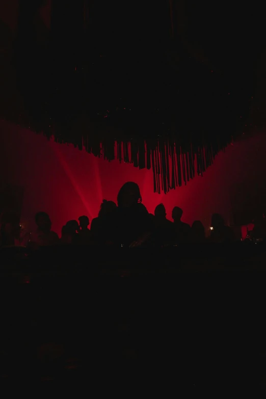 people sitting down at a stage with the light on