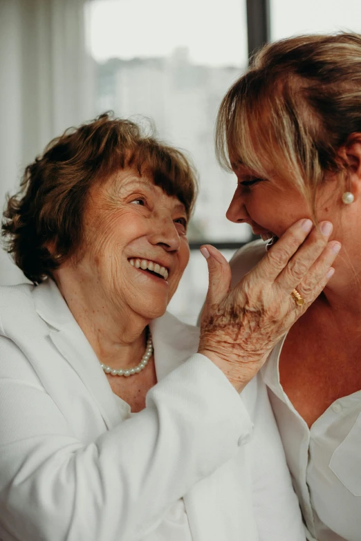 two women talking to each other with their hands together