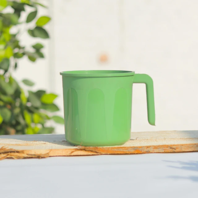 a green mug that is sitting on a table