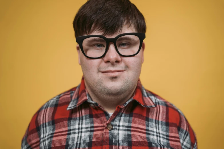 a man with glasses poses for a picture